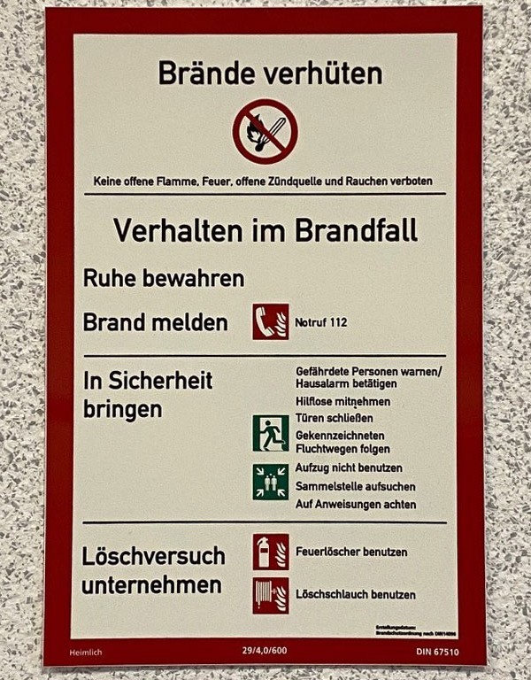 Infotafel zum Thema Brände verhüten an einer Wand in einem Gebäude