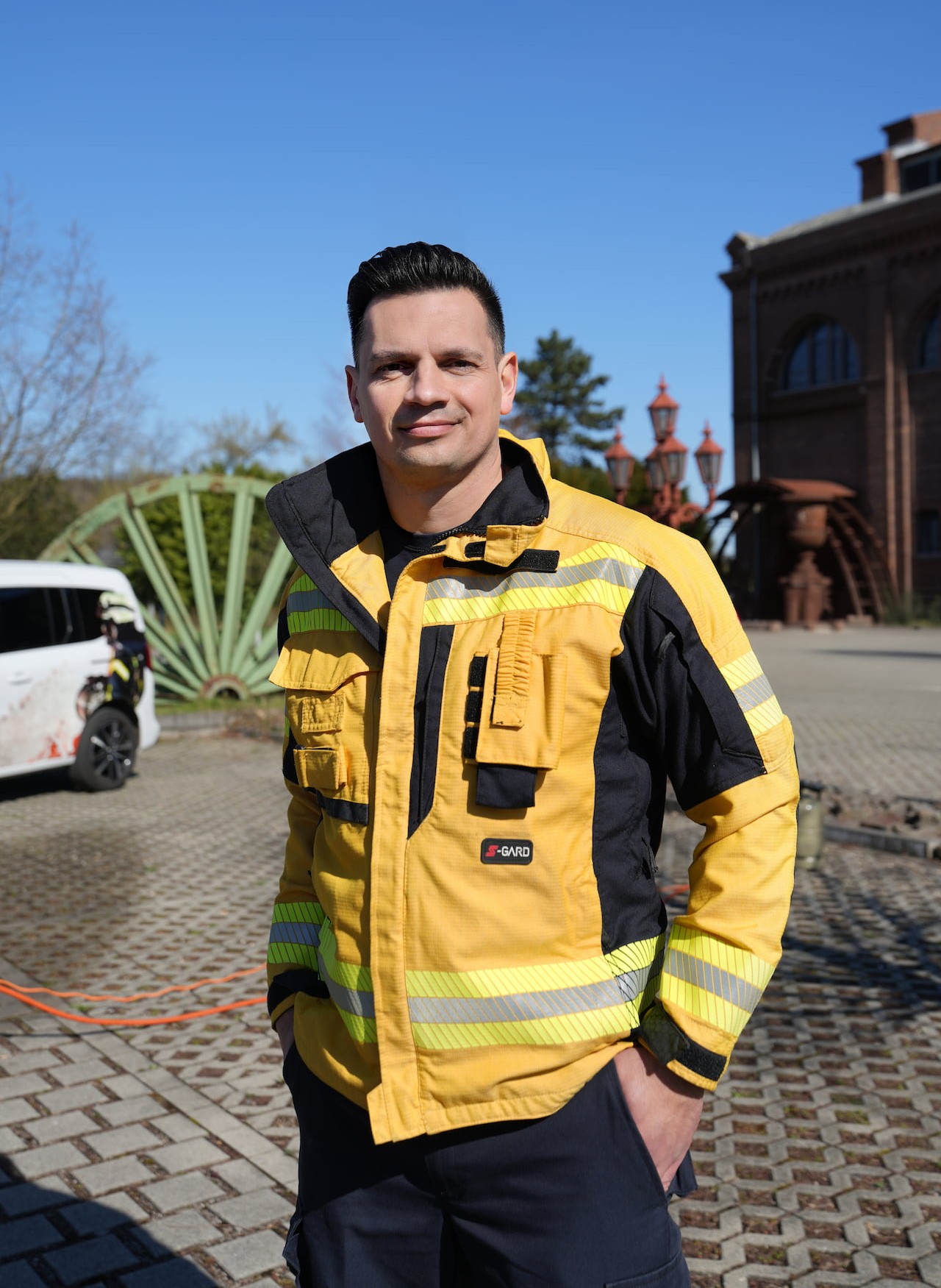 Fabian Lichte in gelber Feuerschutz-Jacke auf einem alten Zechengelände