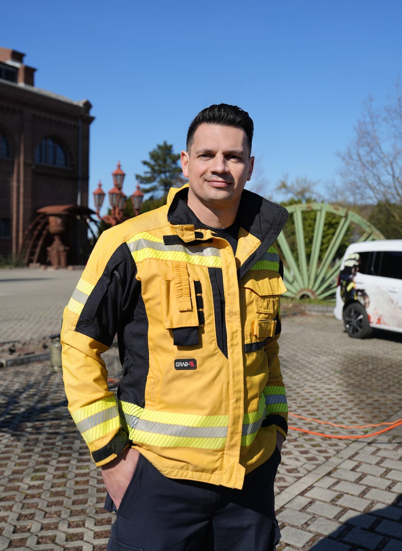 Fabian Lichte in gelber Feuerschutz-Jacke auf einem alten Zechengelände